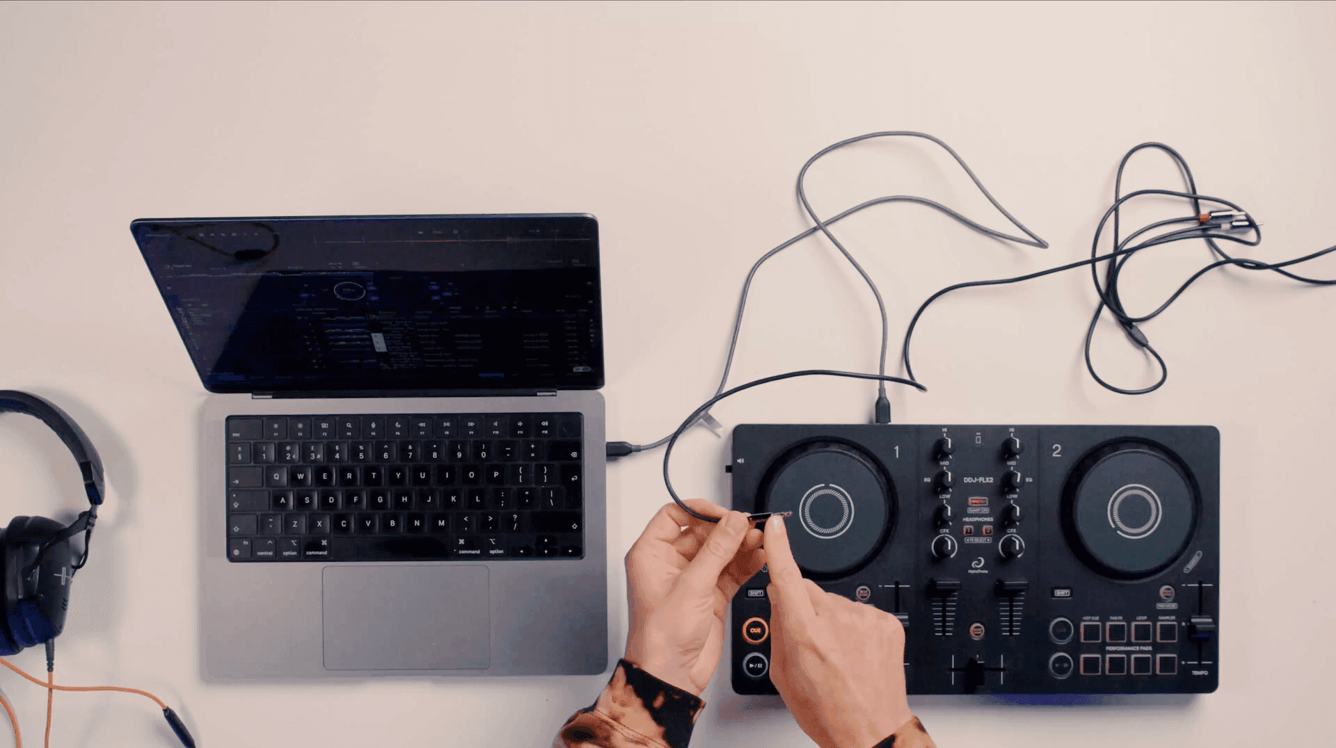Beginner home DJ setup: a laptop, headphones and a DDJ-FLX2 controller seen from above